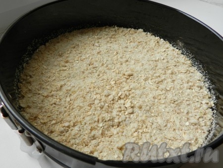 Разъемную форму для выпечки смазать маслом, на дно формы выложить слой овсяного теста.