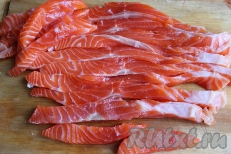 Форель (или другую красную рыбу) нарезать продолговатыми кусочками, можно использовать целый длинный кусочек или сложить начинку из нескольких коротких.
