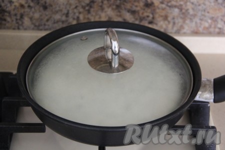 Накрыть сковороду крышкой и готовить ленивое хачапури с творогом на среднем огне 5 минут.