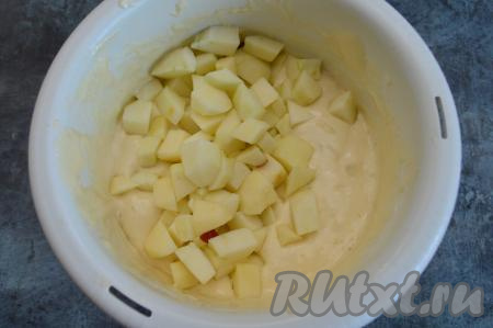 Яблоки очистите от кожуры и семечек, нарежьте на кубики размером примерно 1,5 на 1,5 сантиметра. Вмешайте яблоки в тесто при помощи лопатки.