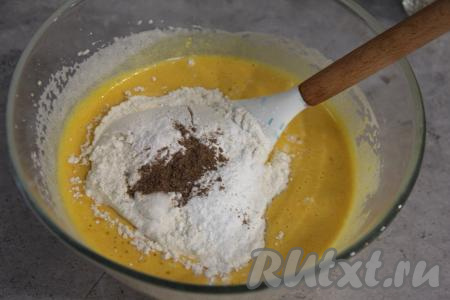Затем всыпать половину просеянной муки, ванилин, соль, разрыхлитель и корицу, перемешать тыквенное тесто для кекса лопаткой.