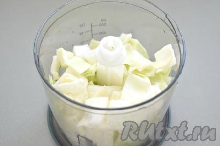 Свежую белокочанную капусту нарезаем на небольшие кусочки и складываем в чашу измельчителя, прокручиваем. Если такого измельчителя нет, можно мелко нарезать капусту или натереть её на тёрке.