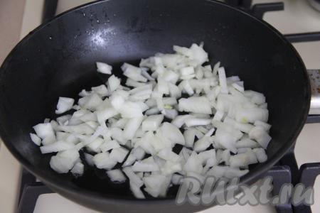 В сковороде прогреть растительное масло, выложить мелко нарезанный лук и обжарить его до мягкости (в течение 4-5 минут) на среднем огне, не забывая иногда помешивать. 