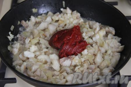 Обжарить рыбку с луком в течение 5 минут, иногда помешивая. Затем добавить томатную пасту, соль и влить воду.