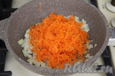После того как лук станет прозрачным, добавить в сковороду морковку, натёртую на мелкой тёрке, перемешать.