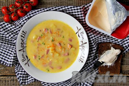 Вкусный, насыщенный суп, сваренный с варёной колбасой и плавленным сыром, разлить по тарелкам и подать к столу.