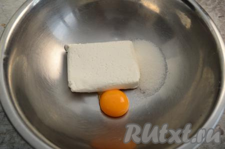 В глубокую миску выложить творог и яичный желток, всыпать сахар.