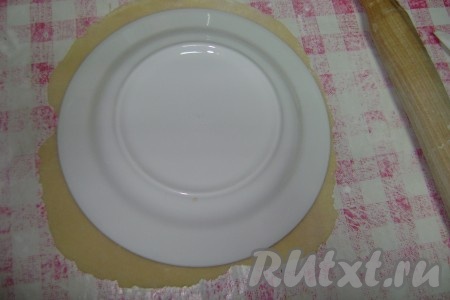 Тонко раскатать каждый колобок на присыпанной мукой поверхности при помощи скалки. Вырезать из раскатанного теста круглый блин, используя тарелку (диаметр тарелки должен соответствовать диаметру сковороды, на которой вы будете готовить торт).