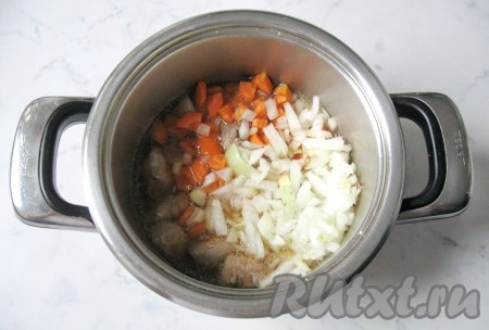Морковь и репчатый лук почистить, вымыть и мелко нарезать. Жареные кусочки свинины выложить в кастрюлю с толстым дном, добавить морковь и лук, налить воду, чтобы она покрыла свинину с овощами. Поставить на огонь, довести до кипения и тушить мясо на небольшом огне под крышкой минут 25.